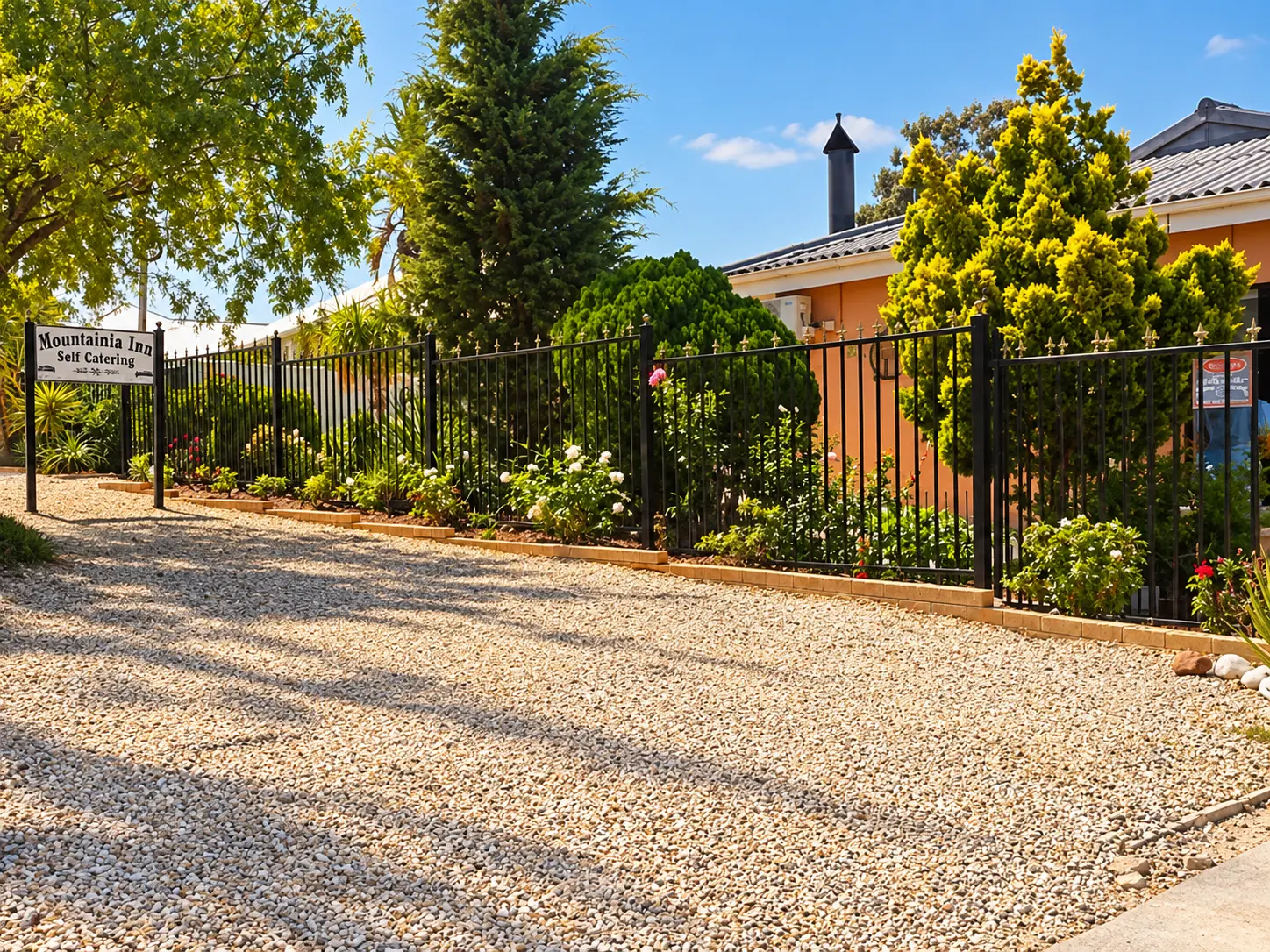 Mountainia Inn exterior and garden fence along the gravel driveway