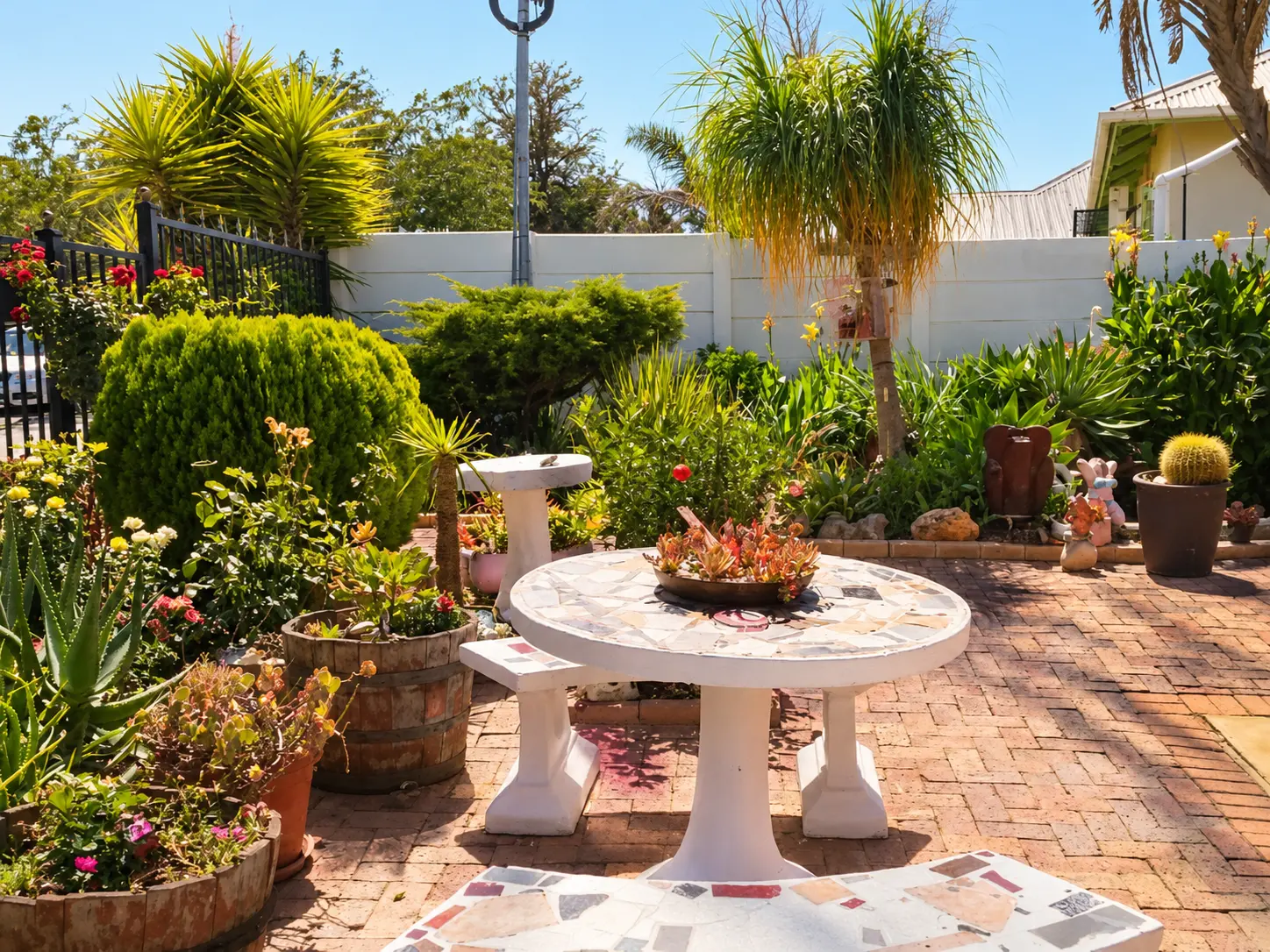 Sunny courtyard patio with mosaic table and potted plants