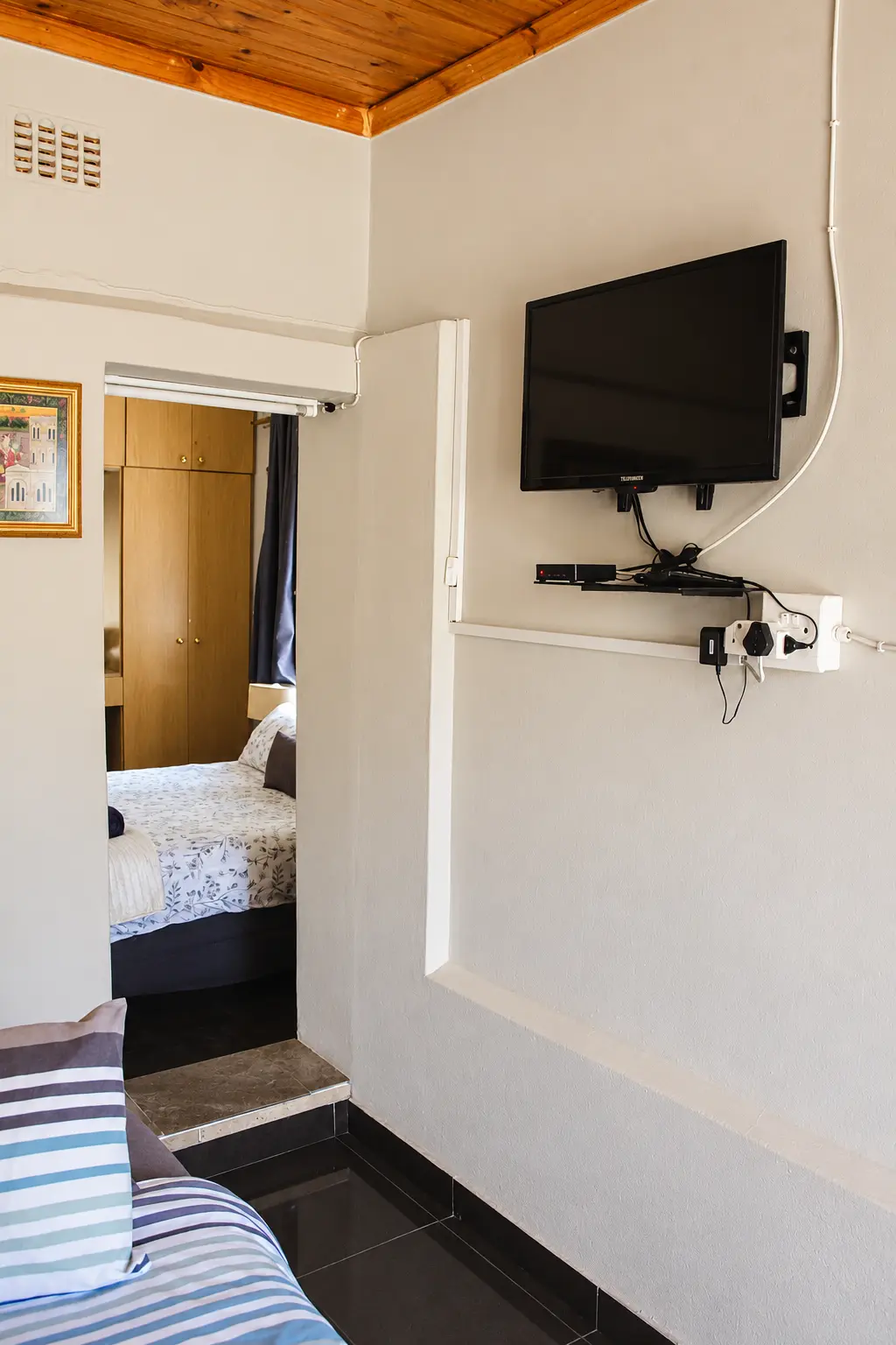 Second bedroom of the Aloe room with wall-mounted TV